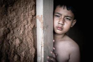 poco ragazzo con occhio triste e senza speranza. umano traffico e paura bambino concetto. foto