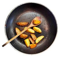 cucinando tradizionale villaggio cibo. fritte patate nel frittura padella e di legno cucchiaio. foto