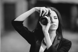 bellissimo femmina fotografo in posa con telecamera foto