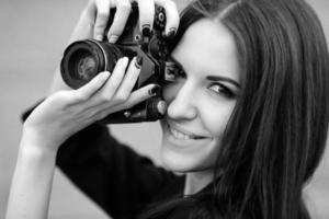 bellissimo femmina fotografo in posa con telecamera foto