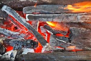 fiamma al di sopra di ardente legno che brucia carboni foto
