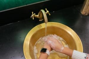 vicino su foto di donna lavaggi sua mani con sapone e acqua.