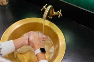 vicino su foto di donna lavaggi sua mani con sapone e acqua.