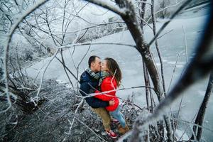 bellissimo coppia in posa vicino un' congelato fiume foto