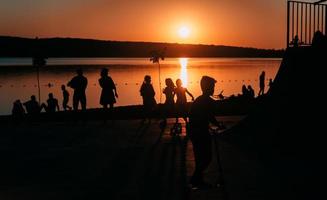 persone siamo riposo su un' gli sport campo di il fiume banca foto