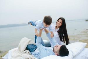 contento giovane famiglia rilassante insieme su il lago foto