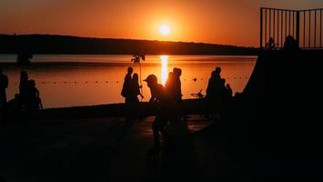 persone siamo riposo su un' gli sport campo di il fiume banca foto