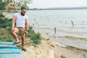 americano barbuto uomo sembra su il fiume banca foto