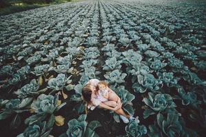 madre e figlia sul campo con cavolo foto