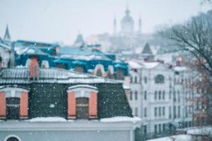 abbondante nevicata al di sopra di il città con il tetti foto