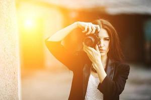 bellissimo femmina fotografo in posa con telecamera foto