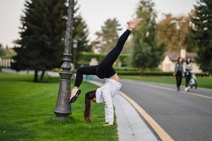 attraente magro donna fare un' backbend mentre mostrando un' capriola. foto