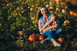 madre e figlia su un' campo con zucche foto