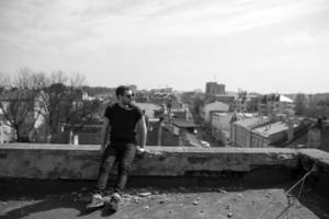 l'uomo con gli stivali e i jeans autentici fa la cimossa sul tetto dell'edificio nel centro storico foto