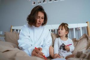 mamma e figlia disegnare nel letto foto