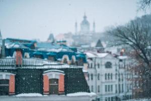 abbondante nevicata al di sopra di il città con il tetti foto