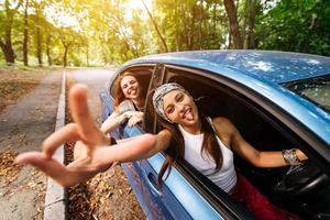 Due amiche scemo in giro e ridendo insieme nel un' auto foto