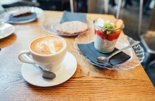 cappuccino con cucchiaio nel tazza e dolce foto