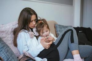 mamma e figlia siamo guardare a il smartphone foto