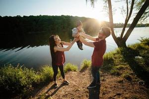 giovane famiglia con un' bambino su il natura foto