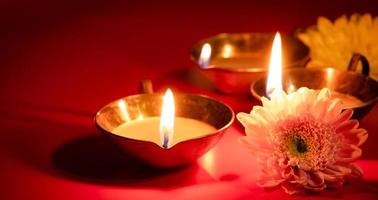 contento diwali. diya olio lampada e fiori su rosso sfondo. tradizionale indù celebrazione. religioso vacanza di luce. foto