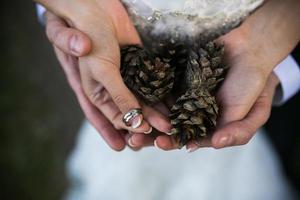 sposa e sposo Tenere nozze anelli e autunno le foglie nel mani foto