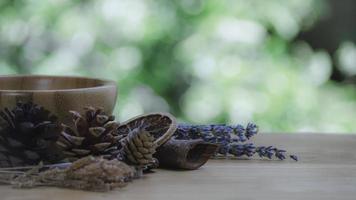 buio bicchiere bottiglia con essenziale olio miscela con cannella, secco agrume fetta, pino ramoscelli, coni e di legno sfondo. natura casa deodoranti e caldo tonica. foto