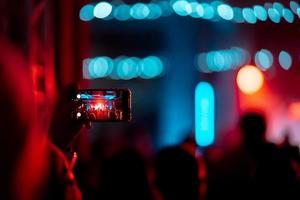 persona vicino su di registrazione video con smartphone durante un' concerto. foto