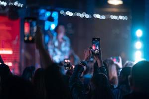 persona vicino su di registrazione video con smartphone durante un' concerto. foto