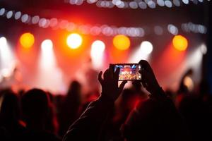 persona vicino su di registrazione video con smartphone durante un' concerto. foto