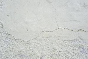 superficie del muro di cemento grigio in crepe foto