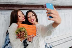 due ragazze fanno selfie con regalo foto