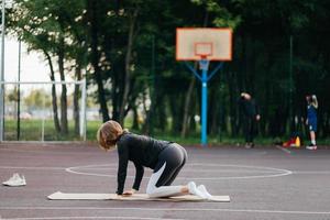 giovane in forma donna nel abbigliamento sportivo treni all'aperto su il terreno di gioco. foto