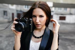 bellissimo femmina fotografo in posa con telecamera foto