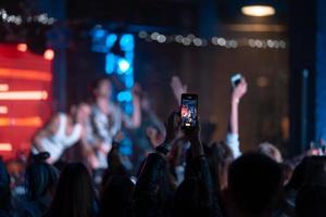 persona vicino su di registrazione video con smartphone durante un' concerto. foto