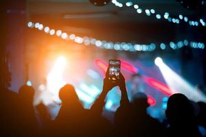 persona vicino su di registrazione video con smartphone durante un' concerto. foto