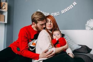 contento famiglia con neonato bambino su il letto foto