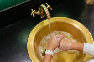 vicino su foto di donna lavaggi sua mani con sapone e acqua.