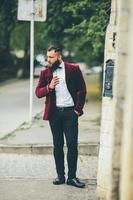 l'uomo ricco con la barba fuma una sigaretta elettronica foto