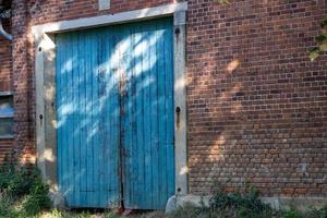 vecchio blu di legno porta con mattone parete foto