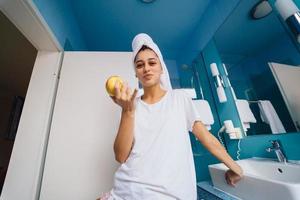 giovane caucasico donna nel bagno, hold Mela. foto