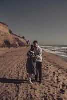 uomo e donna nel ogni altri braccia su il riva del mare foto