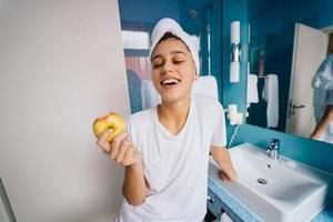 giovane caucasico donna nel bagno, hold Mela. foto