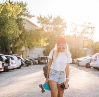 giovane ragazza con un' skateboard su un' auto parco. foto