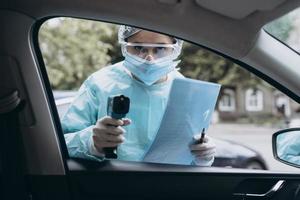 medico donna uso infrarosso termometro pistola per dai un'occhiata corpo temperatura foto