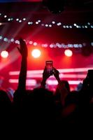 persona vicino su di registrazione video con smartphone durante un' concerto. foto