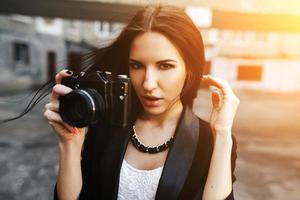 bellissimo femmina fotografo in posa con telecamera foto