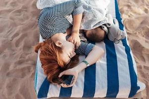 mamma e bambino su il spiaggia addormentato foto