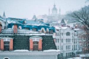 abbondante nevicata al di sopra di il città con il tetti foto