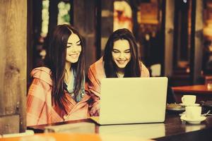 due ragazze che guardano qualcosa nel computer portatile foto